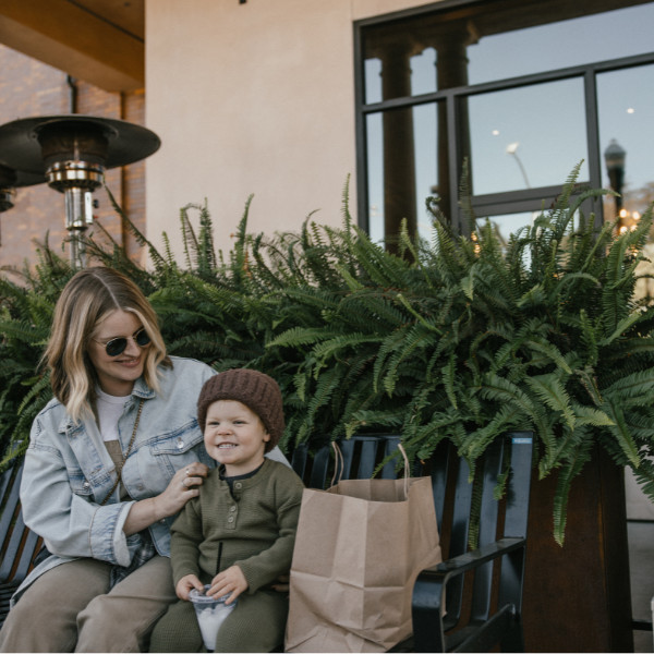 mother and son on bench with shopping bags